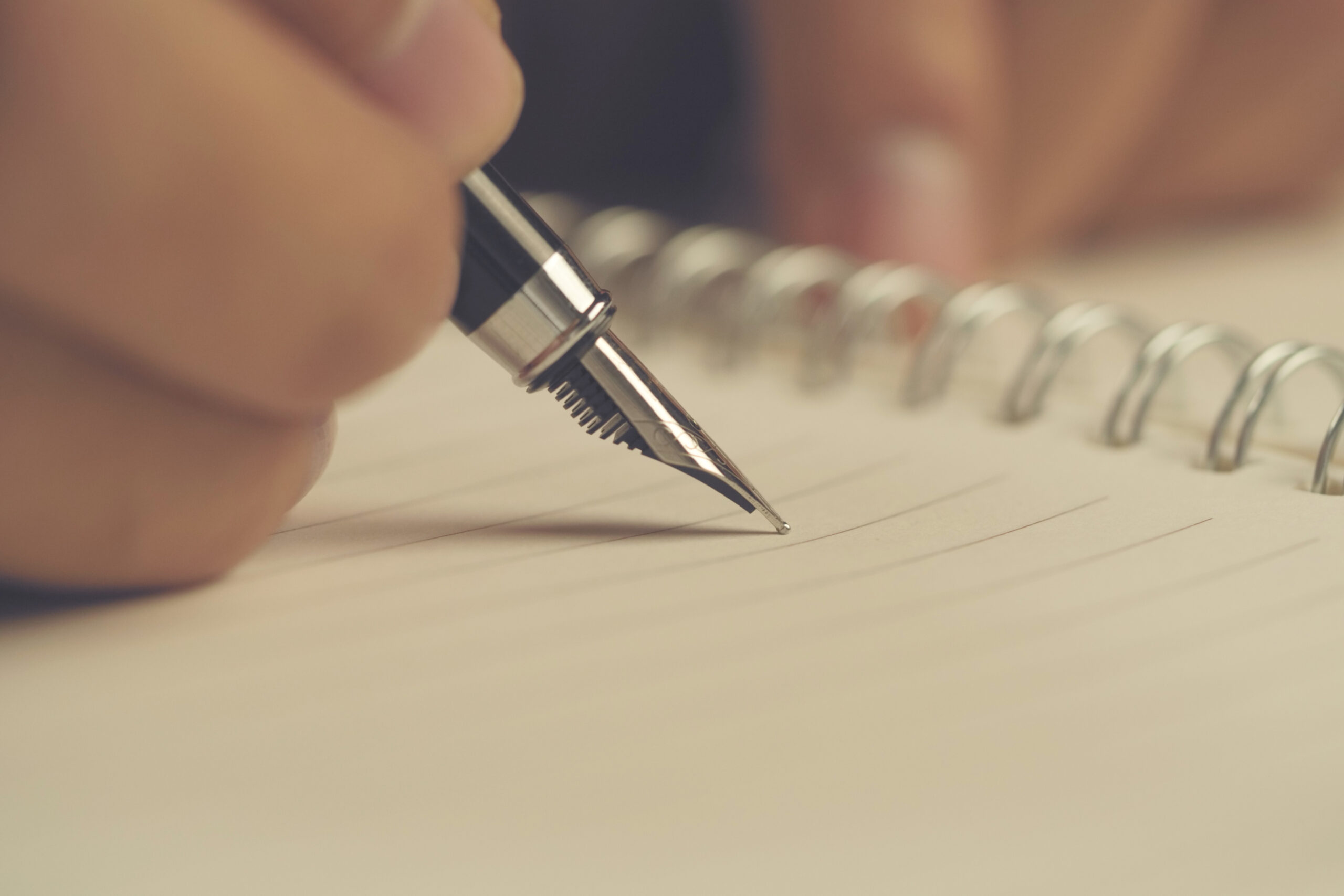 Man hand with pen writing on notebook. Close-up